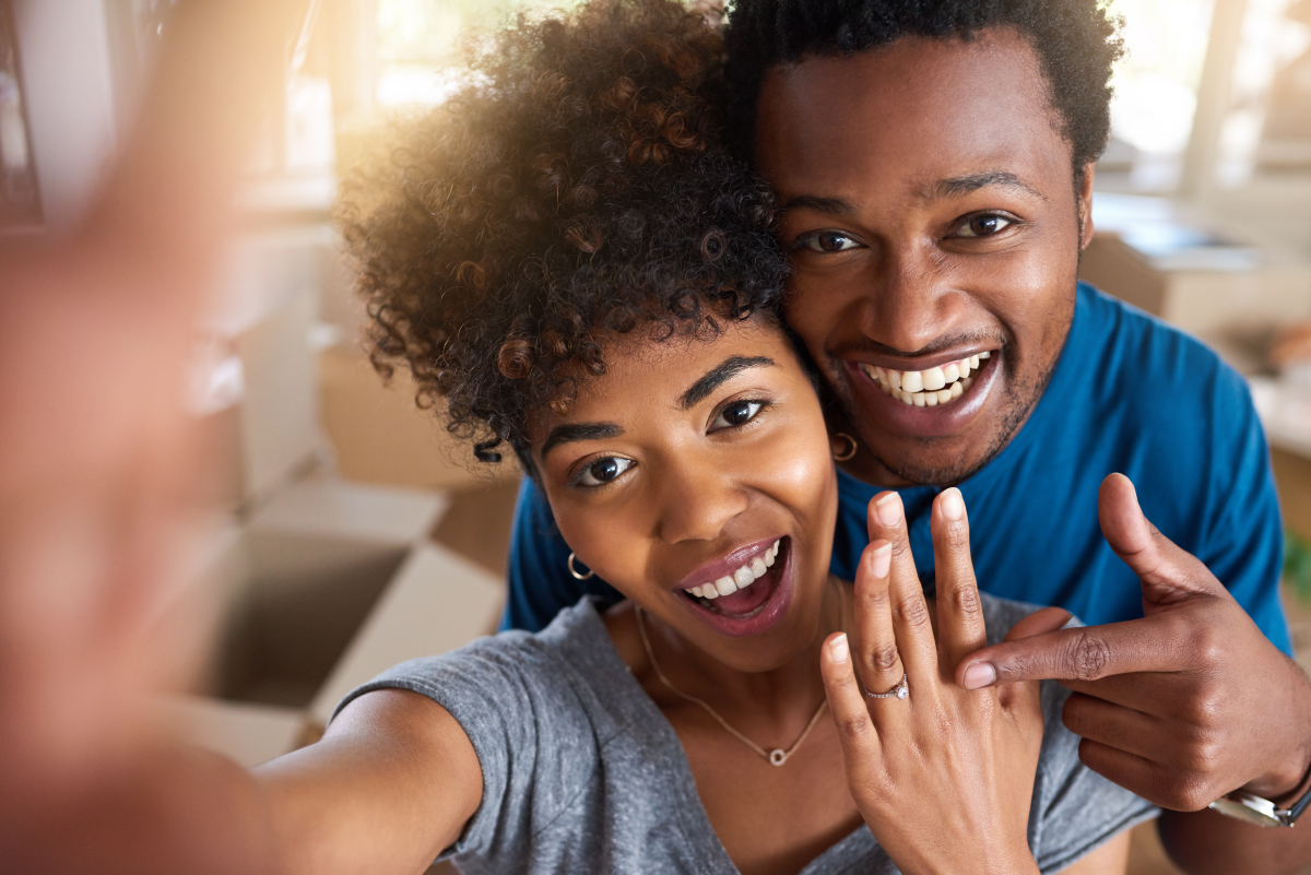 Woman showing off engagement ring as fiance points to ring